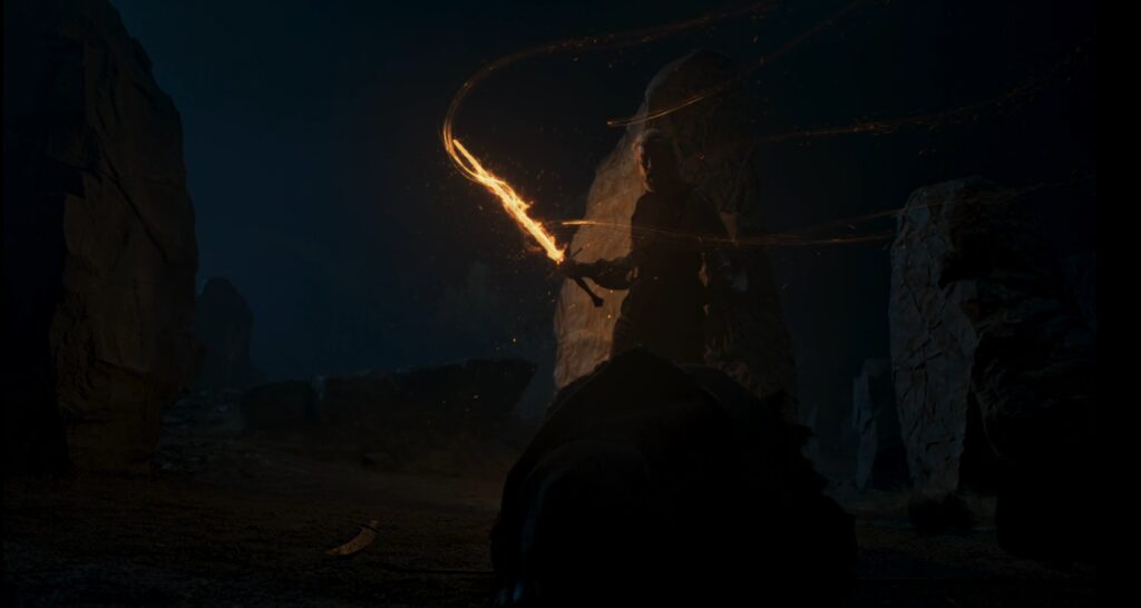 Tomas, flaming sword in hand, stands over a slain Myddraal